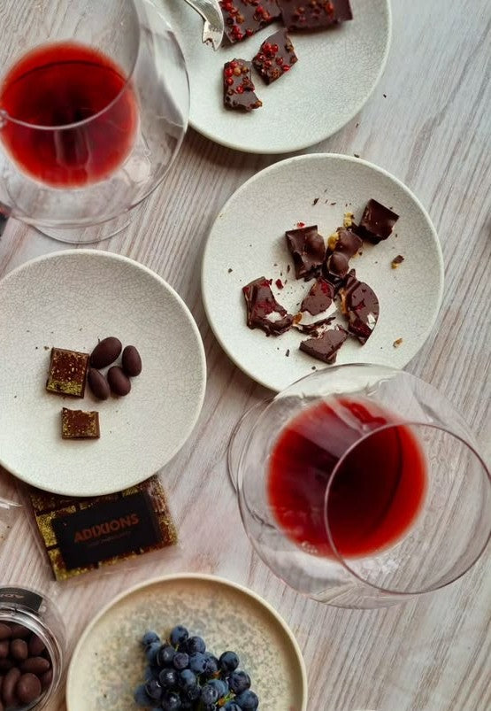 Chokolade og rødvin anrettet på små tallerkener med blåbær og mandler