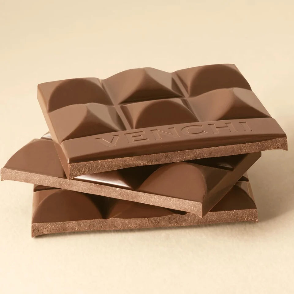 Stablede stykker af brudt Venchi mælkechokolade, der viser tekstur