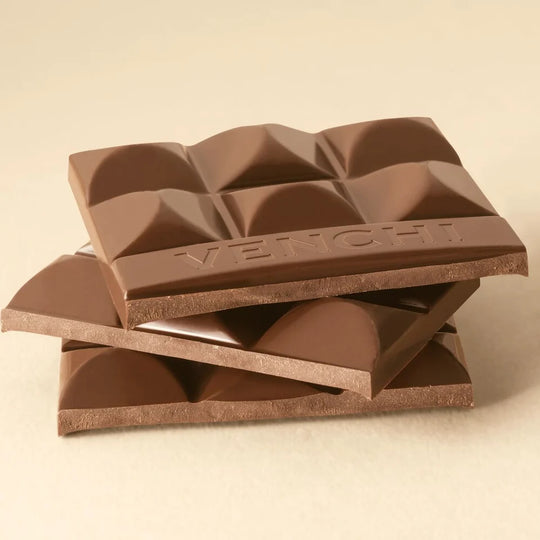 Stablede stykker af brudt Venchi mælkechokolade, der viser tekstur
