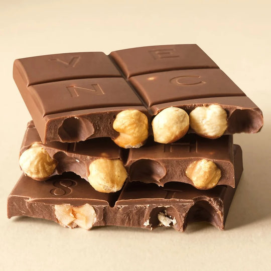 Brudt Venchi mælkechokoladebar, der viser indlejrede ristede hele hasselnødder i gianduja-bund