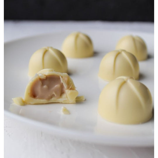 Hvid chokoladepraline med cremet fyld, bidt over