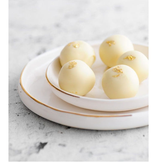 Hvide chokoladeboller dekoreret med guldflager